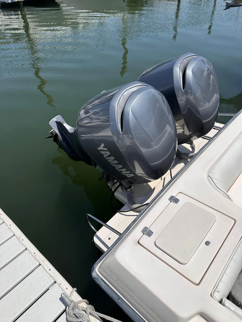 Slide: The Image of 2004 Grady-White Gulfstream 232 boat covered and parked on asphalt at sunset. - 3