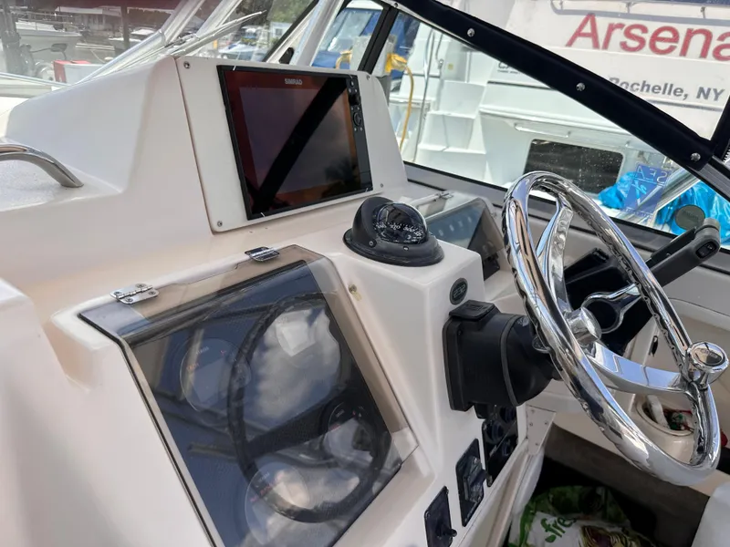 Slide: The Image of 2004 Grady-White Gulfstream 232 boat cockpit with steering wheel and control panel. - 7