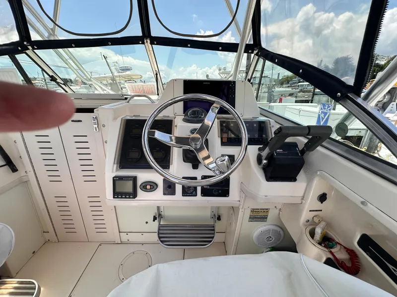 Slide: The Image of 2004 Grady-White Gulfstream 232 boat dashboard with steering wheel and navigation equipment. - 8