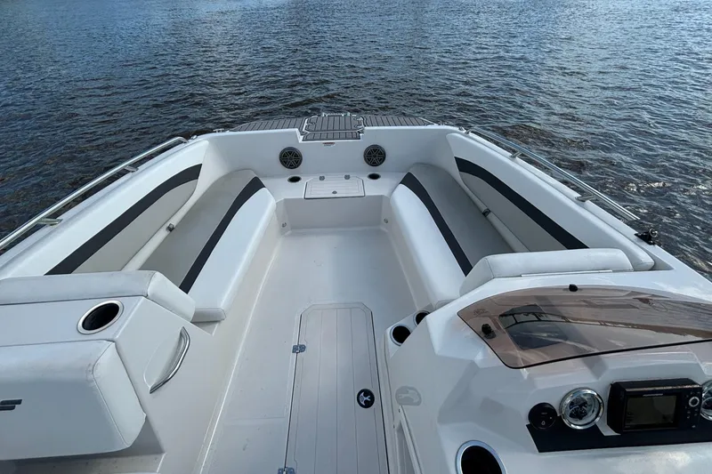 Slide: The Image of 2021 Starcraft SVX 171 OB boat interior with seating, cup holders, and control panel on water. - 1