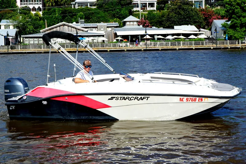 Slide: The Image of 2021 Starcraft SVX 171 OB boat on water, with Yamaha engine, near waterfront buildings. - 4