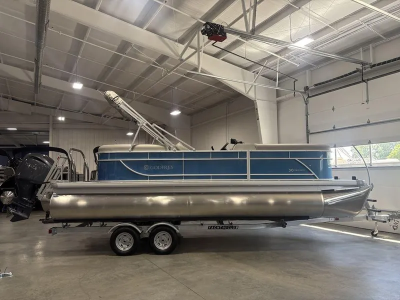 The Image of 2025 Godfrey Xperience 2286 SBX pontoon boat in a showroom, side view. - 1