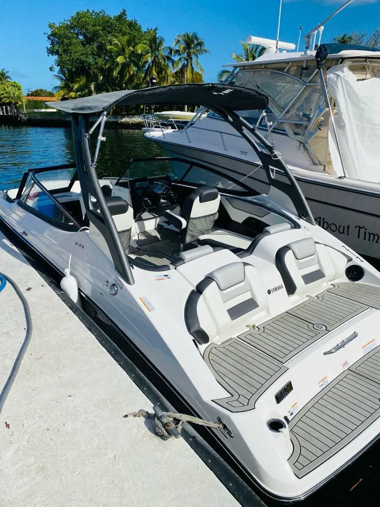 Slide: The Image of 2022 Yamaha Boats 212S docked, featuring sleek design and spacious seating. - 4
