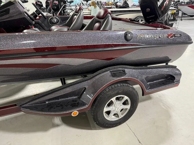 Slide: The Image of 2014 Ranger 118c boat with maroon and gray detailing on a trailer. - 12