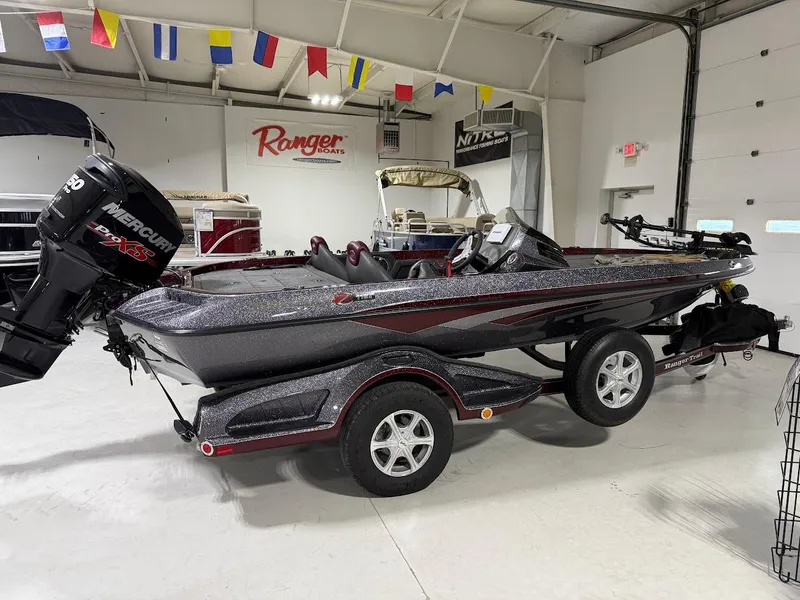 Slide: The Image of 2014 Ranger 118c boat with Mercury engine in showroom, surrounded by colorful flags. - 4