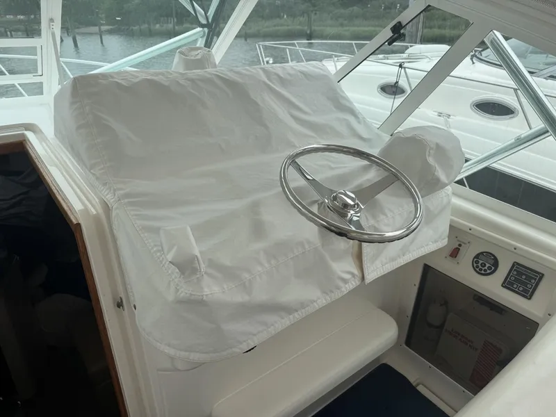 Slide: The Image of Helm of 2000 Cabo 35 Express boat with covered controls and steering wheel. - 4