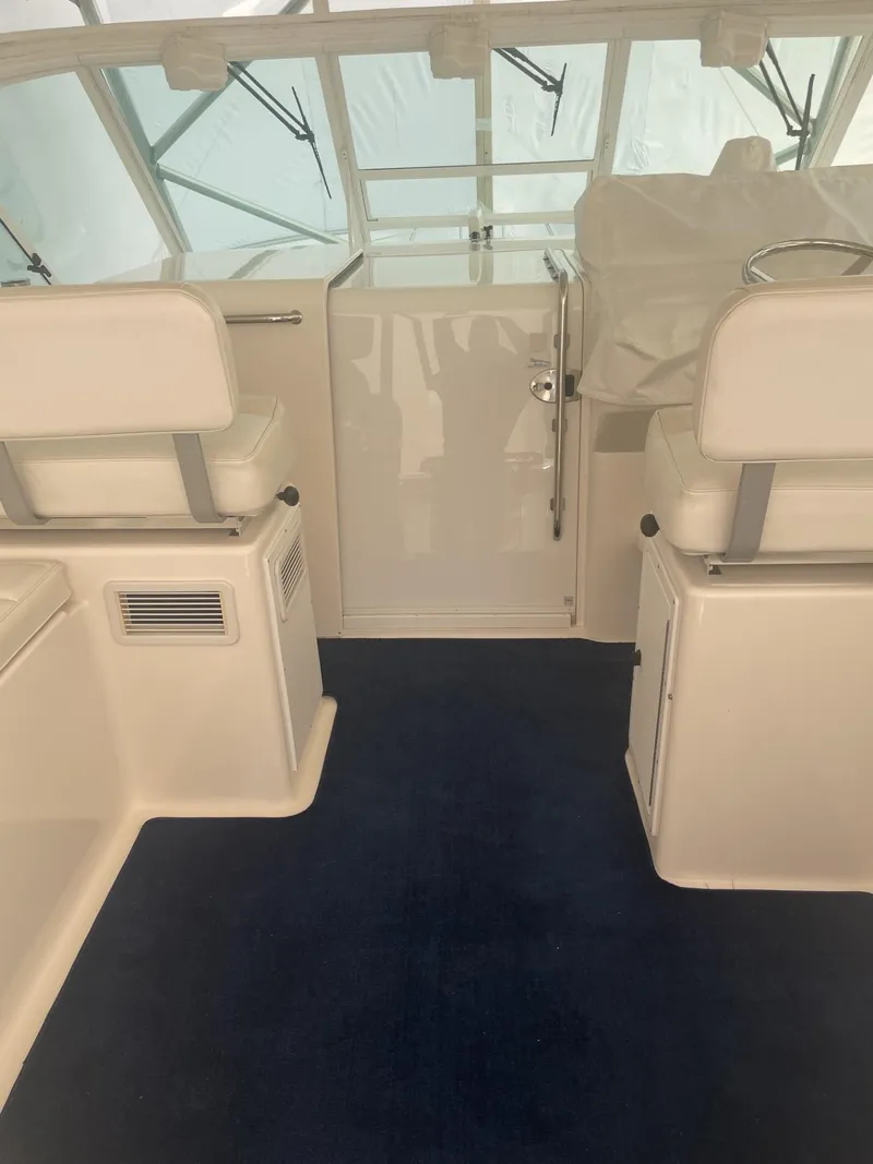 Slide: The Image of Interior of a 2000 Cabo 35 Express boat with white seating and blue carpet. - 6