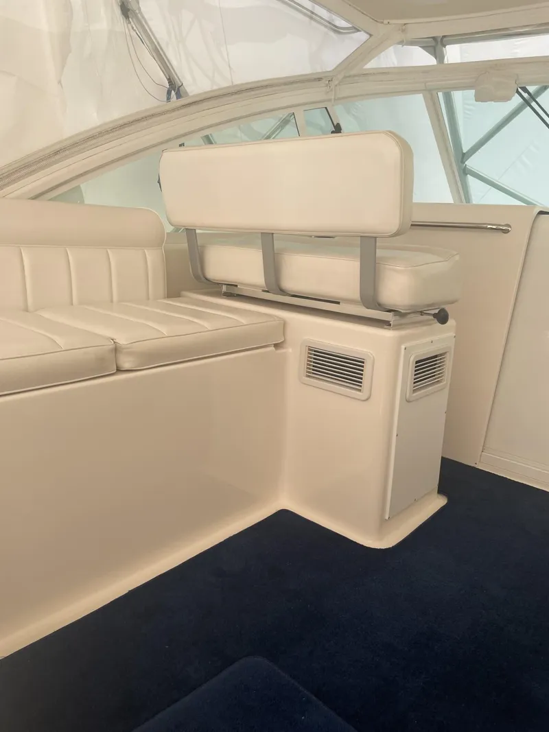 Slide: The Image of Interior of a 2000 Cabo 35 Express boat with white seating and blue carpet. - 7