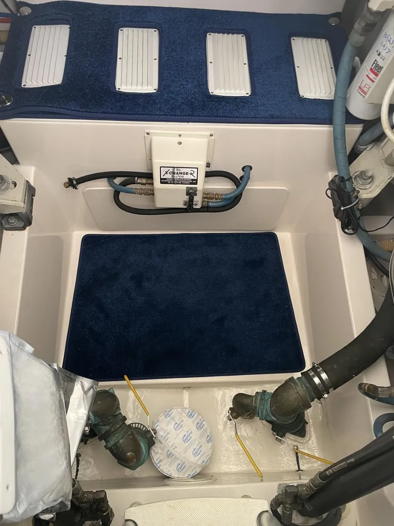 Slide: The Image of Engine compartment of a 2000 Cabo 35 Express boat with blue carpeting and mechanical components. - 8