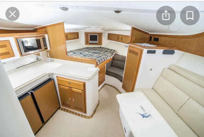 Slide: The Image of Interior of a 2000 Cabo 35 Express yacht with kitchen, bed, and seating area. - 9