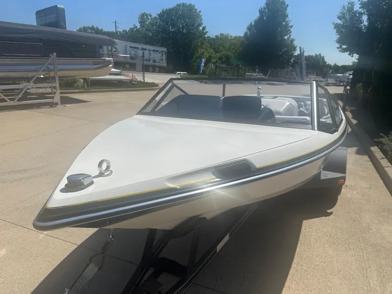 Slide: The Image of 1989 MasterCraft ProStar 190 boat on trailer, parked outdoors in sunny weather. - 13