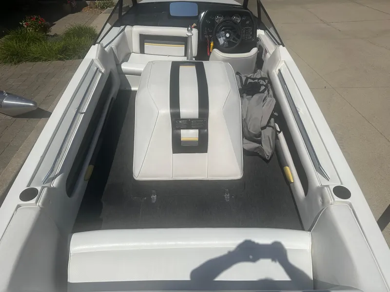 Slide: The Image of 1989 MasterCraft ProStar 190 interior with white seating and dashboard, parked on pavement. - 4