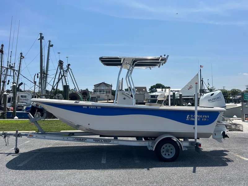The Image of 2022 Carolina Skiff 19 LS boat on trailer, dockside with clear blue sky. - 0