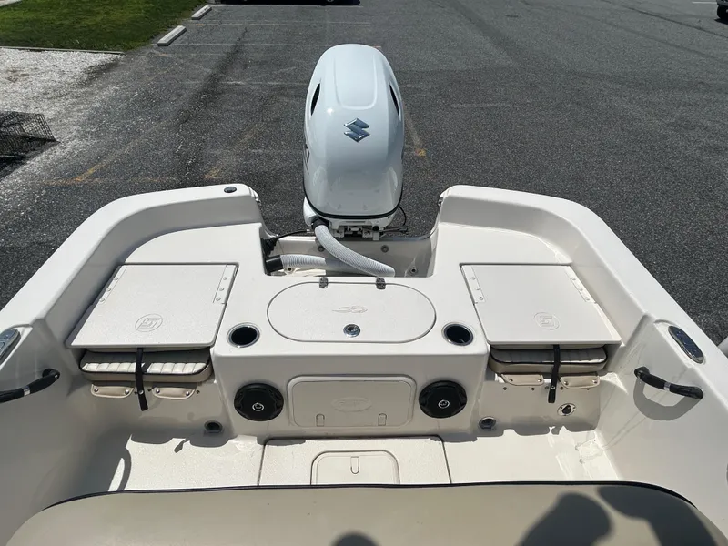 Slide: The Image of 2022 Carolina Skiff 19 LS boat interior with Suzuki outboard motor, storage compartments, and seating. - 11