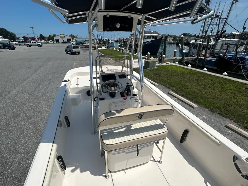 Slide: The Image of 2022 Carolina Skiff 19 LS boat docked, featuring center console and seating, in a marina setting. - 14