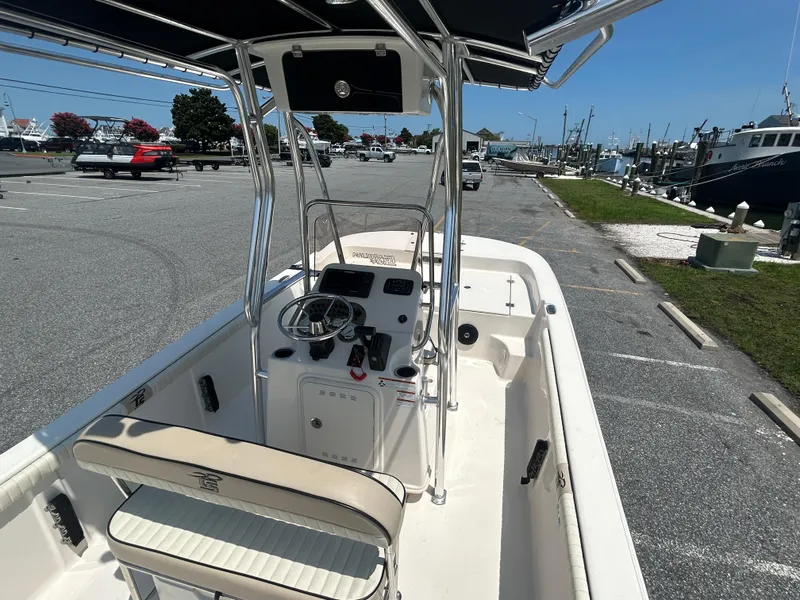 Slide: The Image of 2022 Carolina Skiff 19 LS boat interior with steering console and seating, parked at marina. - 15