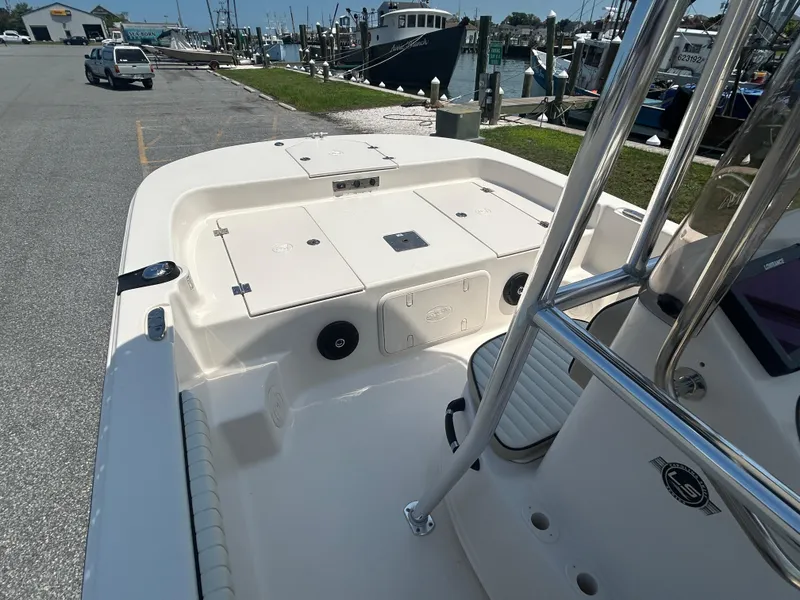 Slide: The Image of 2022 Carolina Skiff 19 LS boat interior at marina, featuring storage compartments and seating. - 21