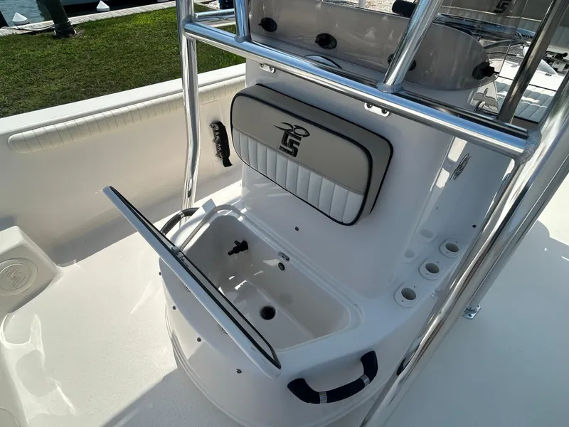 Slide: The Image of 2022 Carolina Skiff 19 LS boat interior with open storage compartment and rod holders. - 24