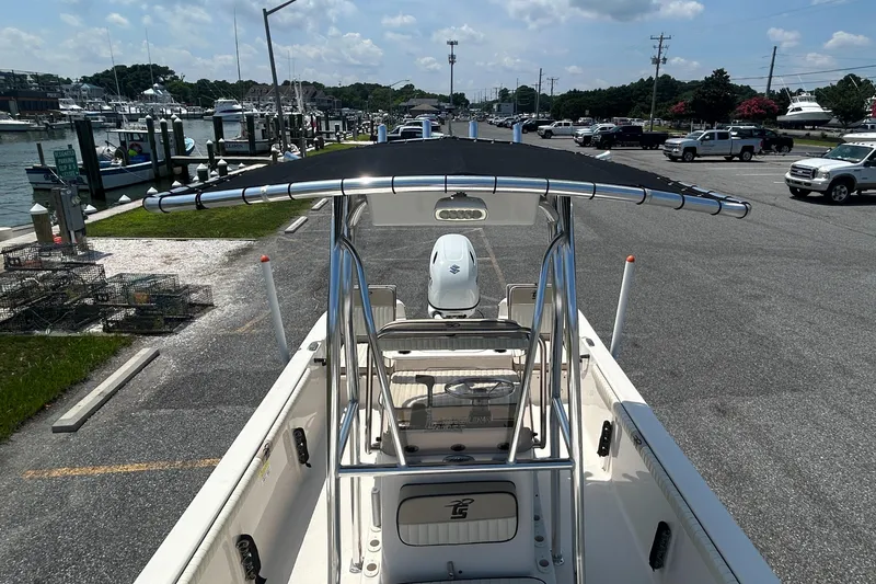 Slide: The Image of 2022 Carolina Skiff 19 LS boat at marina, featuring T-top and Suzuki outboard motor. - 26