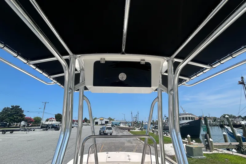 Slide: The Image of 2022 Carolina Skiff 19 LS boat with T-top, docked at marina under clear blue sky. - 27