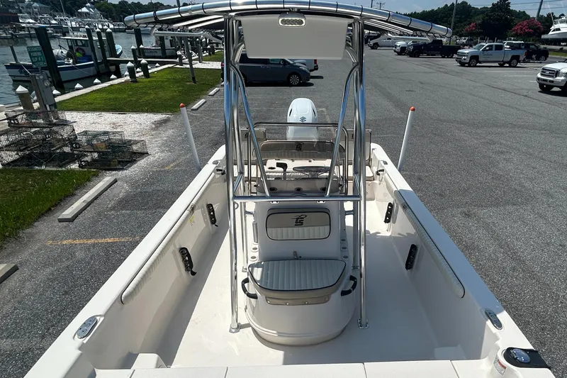 Slide: The Image of 2022 Carolina Skiff 19 LS boat at marina, featuring center console and T-top. - 28