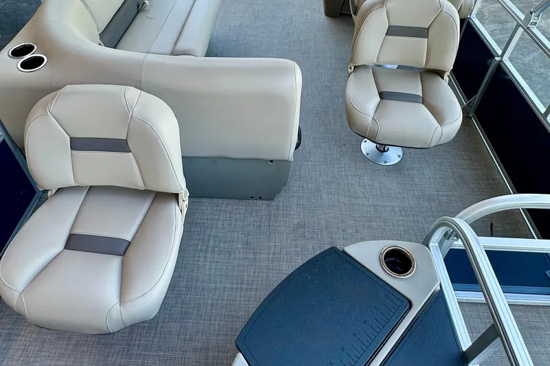 Slide: The Image of 2025 Sun Tracker Bass Buggy 18 DLX interior with beige seating and cup holders. - 2