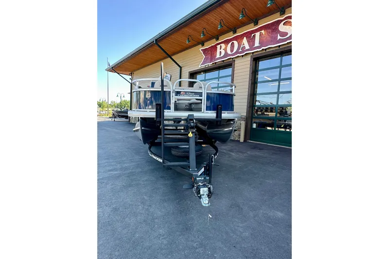 Slide: The Image of 2025 Sun Tracker Bass Buggy 18 DLX pontoon boat outside a boat shop. - 93
