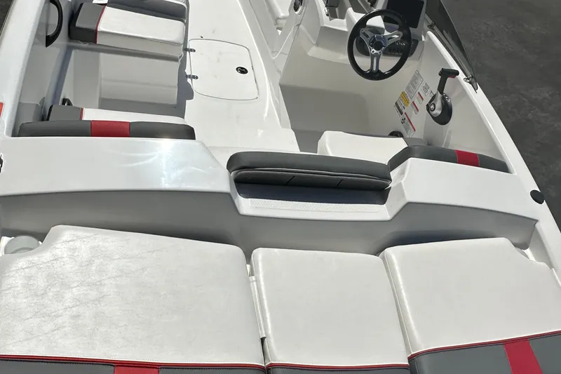 Slide: The Image of 2025 Tahoe T16 boat interior with white and red seating, steering wheel, and control panel. - 2