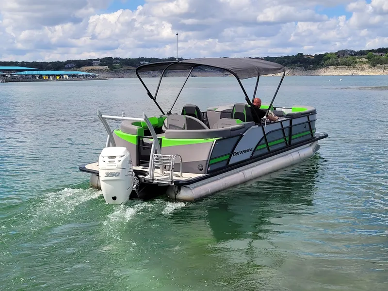 Slide: The Image of 2023 Berkshire 25RFX STS 3.0+ pontoon boat cruising on a lake under a cloudy sky. - 13