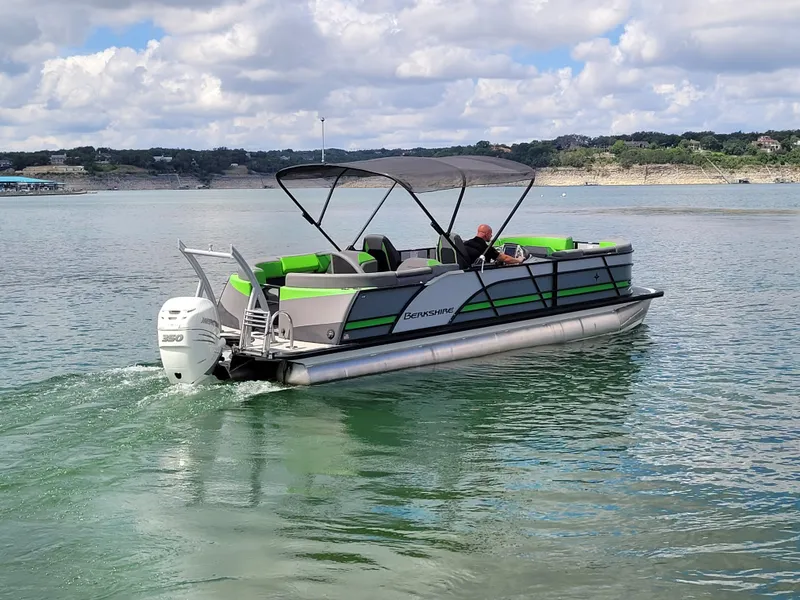 Slide: The Image of 2023 Berkshire 25RFX STS 3.0+ pontoon boat cruising on a lake under a cloudy sky. - 14