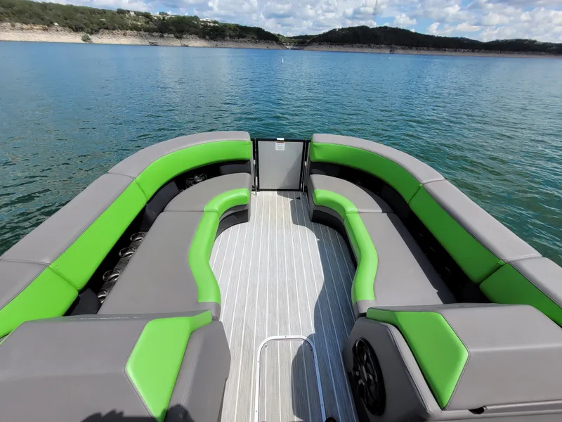Slide: The Image of 2023 Berkshire 25RFX STS 3.0+ pontoon boat with green and gray seating on a lake. - 15