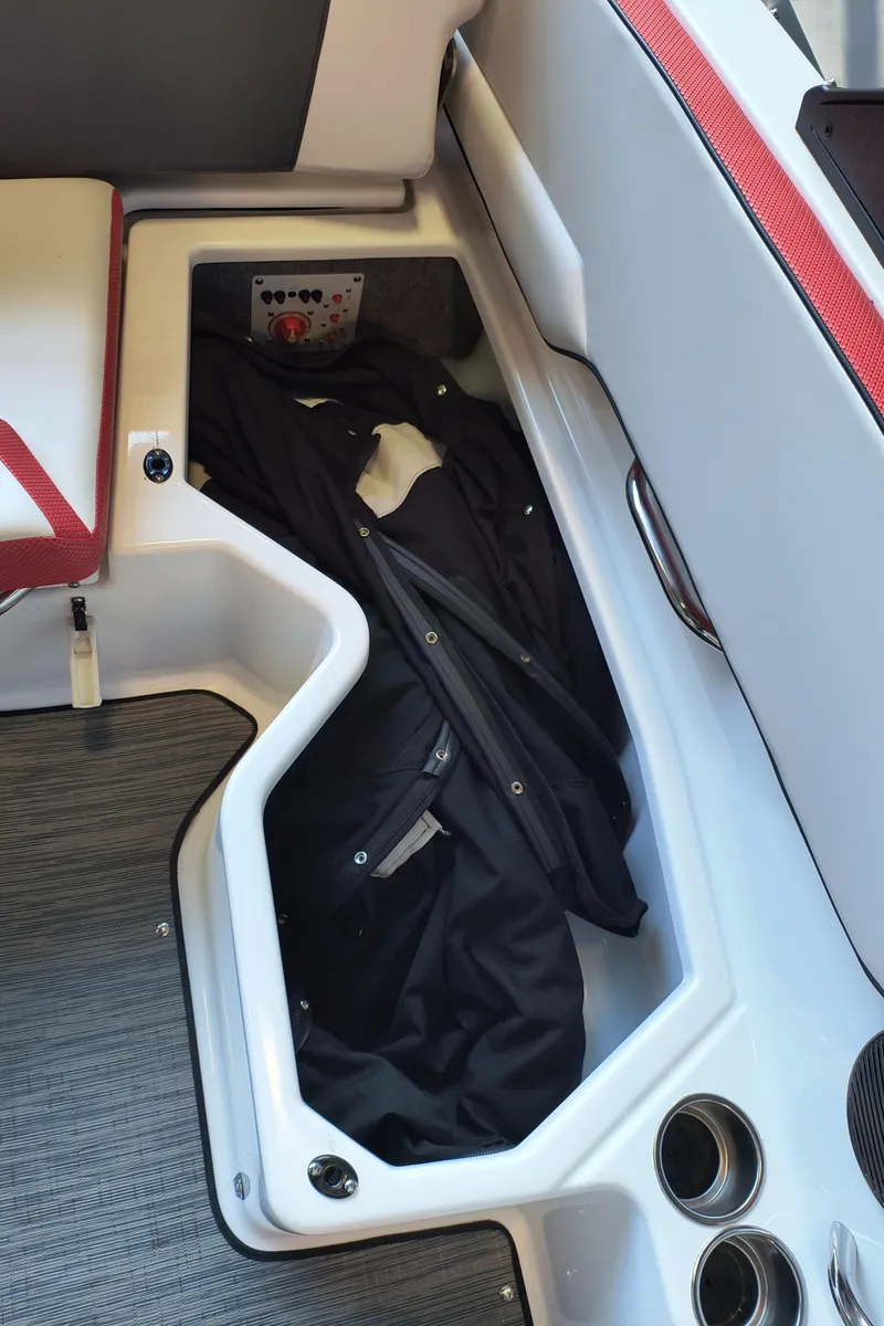 Slide: The Image of Storage compartment in 2023 Scarab 195 ID boat with black jacket inside. - 31