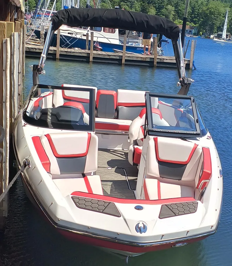 Slide: The Image of 2023 Scarab 195 ID boat docked, featuring red and white seating, in a marina setting. - 5