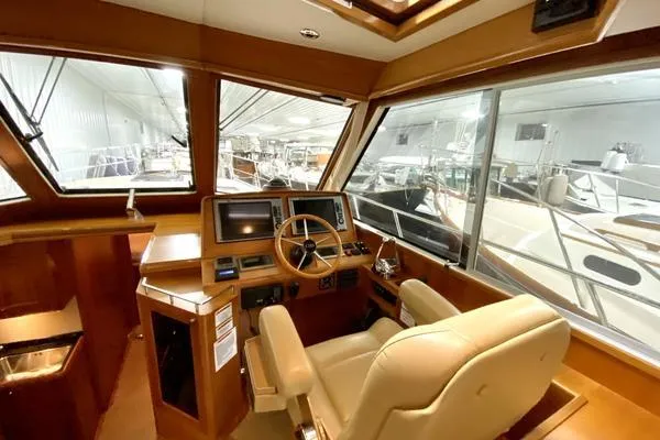 Slide: The Image of 2011 Grand Banks 46 Eastbay SX yacht cruising on open water with American flag. - 18