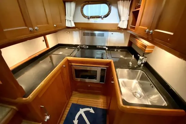 Slide: The Image of 2011 Grand Banks 46 Eastbay SX yacht cruising on open water with American flag. - 26