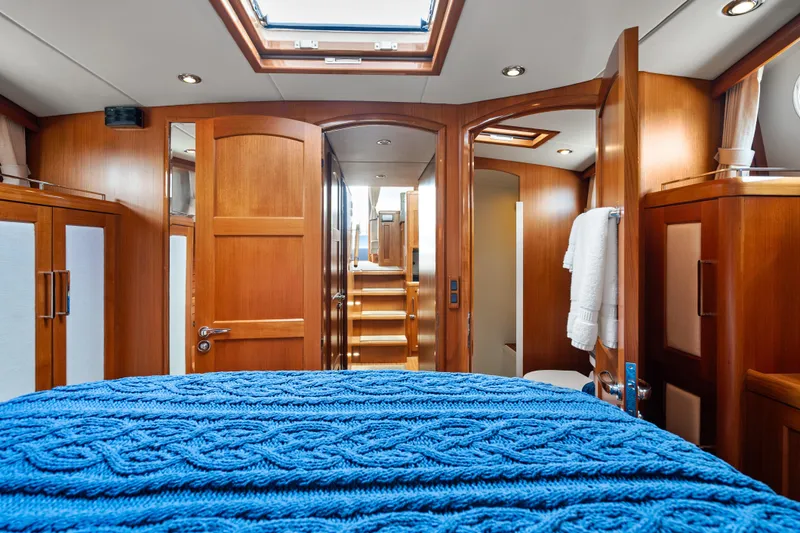 Slide: The Image of Luxurious 2011 Grand Banks 46 Eastbay SX yacht interior with wooden finishes and blue bedding. - 51
