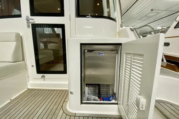 Slide: The Image of 2011 Grand Banks 46 Eastbay SX cruising on open water, scenic shoreline in background. - 7