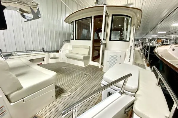 Slide: The Image of 2011 Grand Banks 46 Eastbay SX cruising on open water, scenic shoreline in background. - 8