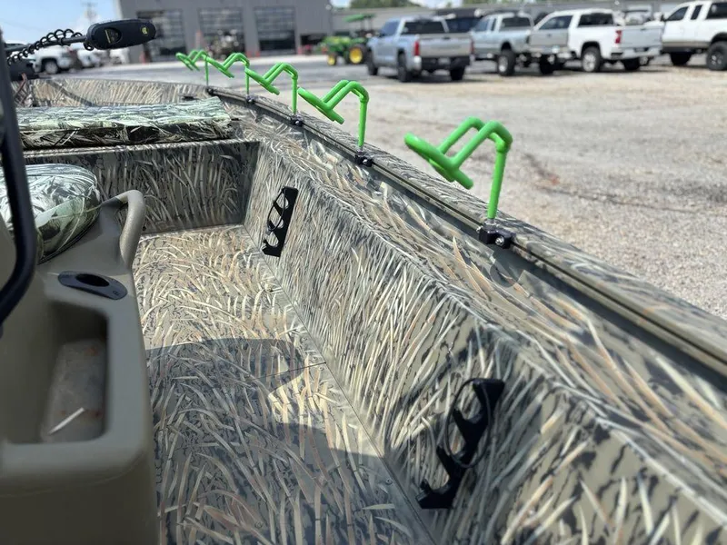 Slide: The Image of 2025 Tracker GRIZZLY® 1860 CC boat interior with camo design and green rod holders. - 16