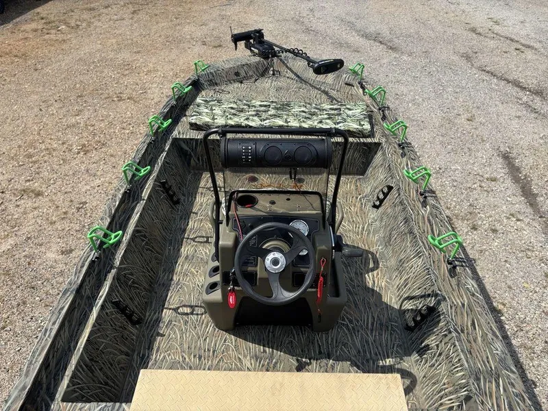 Slide: The Image of 2025 Tracker GRIZZLY® 1860 CC boat interior with camouflage design and steering console. - 19