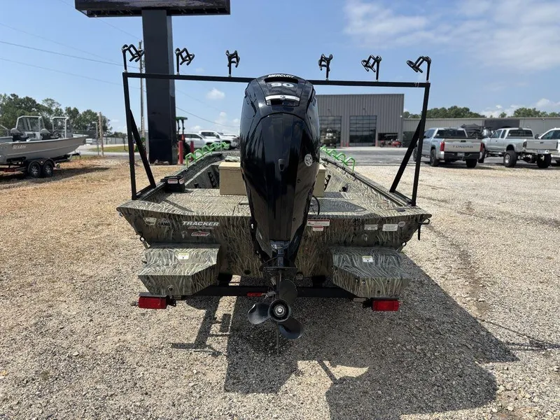 Slide: The Image of 2025 Tracker GRIZZLY® 1860 CC boat with motor, parked on gravel lot. - 3