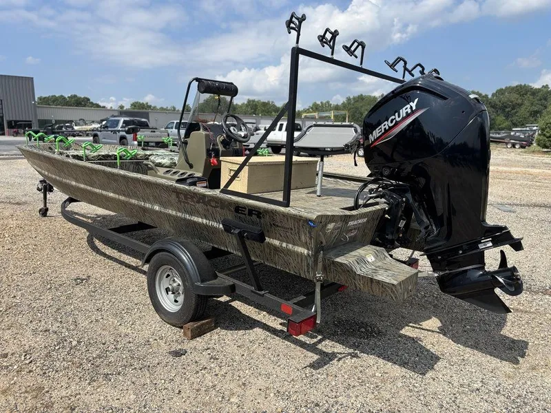 Slide: The Image of 2025 Tracker GRIZZLY® 1860 CC boat with Mercury engine on trailer, parked outdoors. - 4