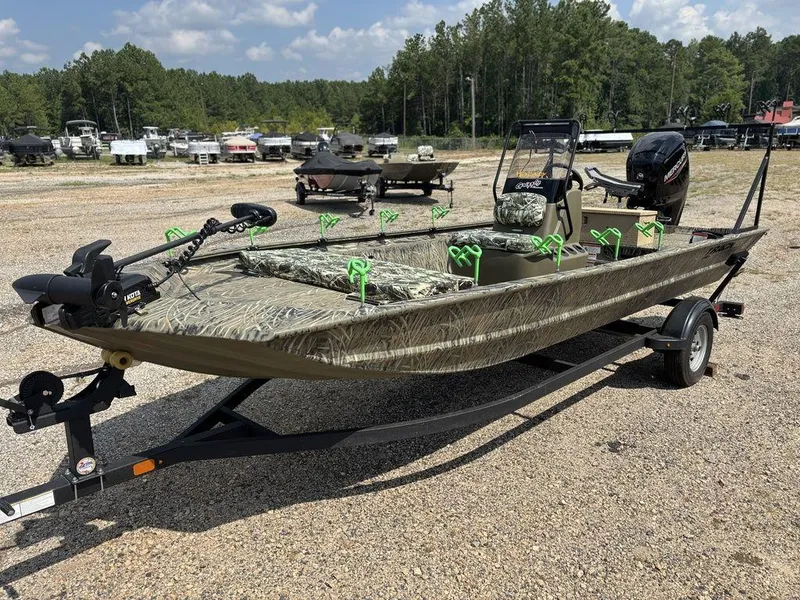 Slide: The Image of 2025 Tracker GRIZZLY® 1860 CC boat on trailer, camo design, parked outdoors. - 5