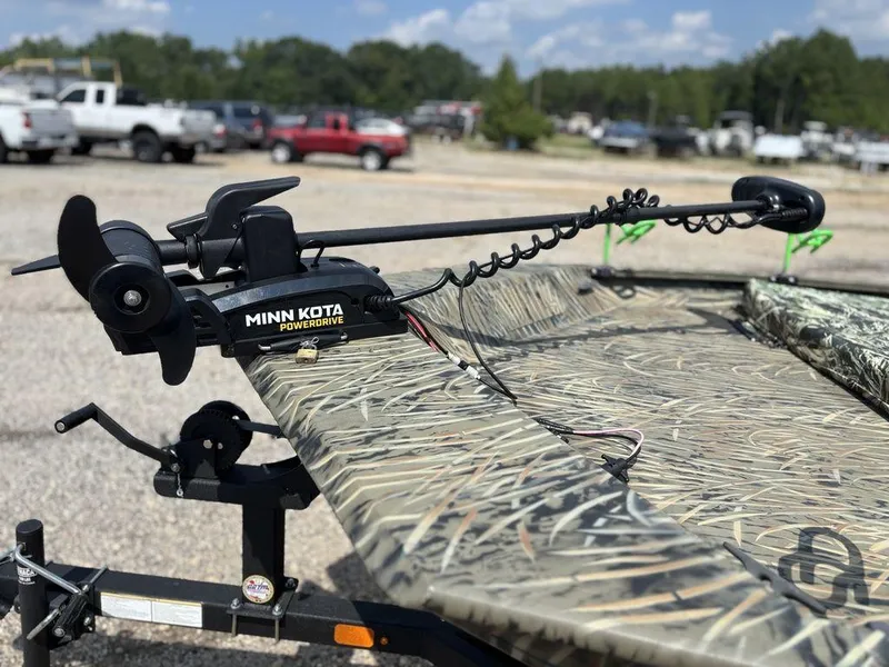 Slide: The Image of Minn Kota PowerDrive on 2025 Tracker GRIZZLY® 1860 CC boat, camo design, outdoor setting. - 9