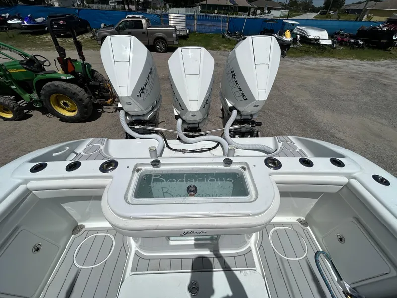 Slide: The Image of 2019 Yellowfin 36 Offshore boat with triple outboard engines, docked outdoors. - 25