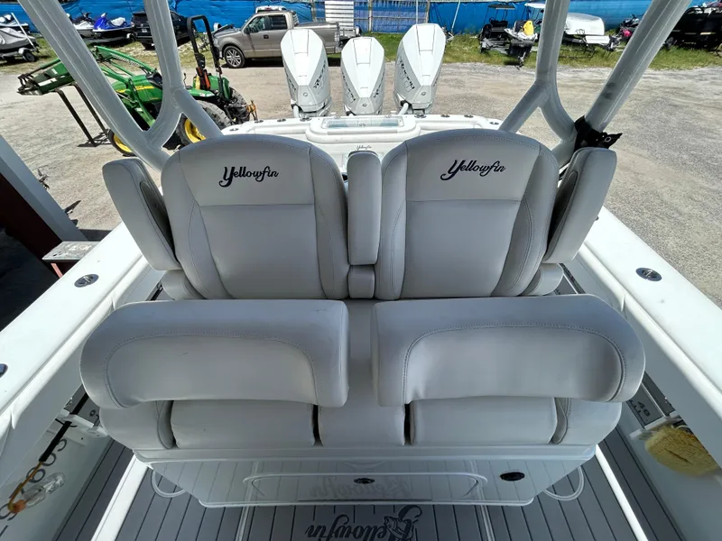 Slide: The Image of 2019 Yellowfin 36 Offshore boat with white cushioned seats and triple outboard motors. - 7