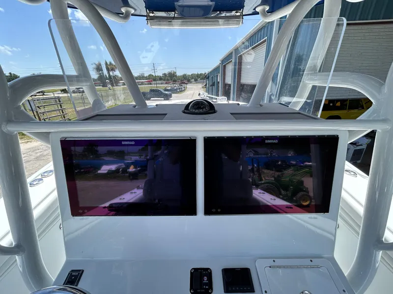 Slide: The Image of 2019 Yellowfin 36 Offshore boat dashboard with dual Simrad displays and navigation equipment. - 8