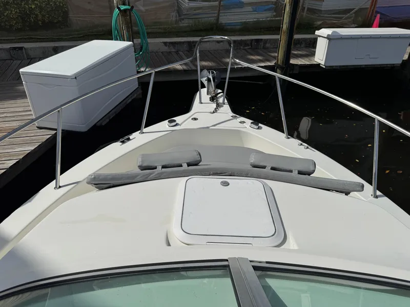 Slide: The Image of 2005 Hydra-Sports Lightning 230 WA boat bow at dock, featuring railing and hatch. - 11