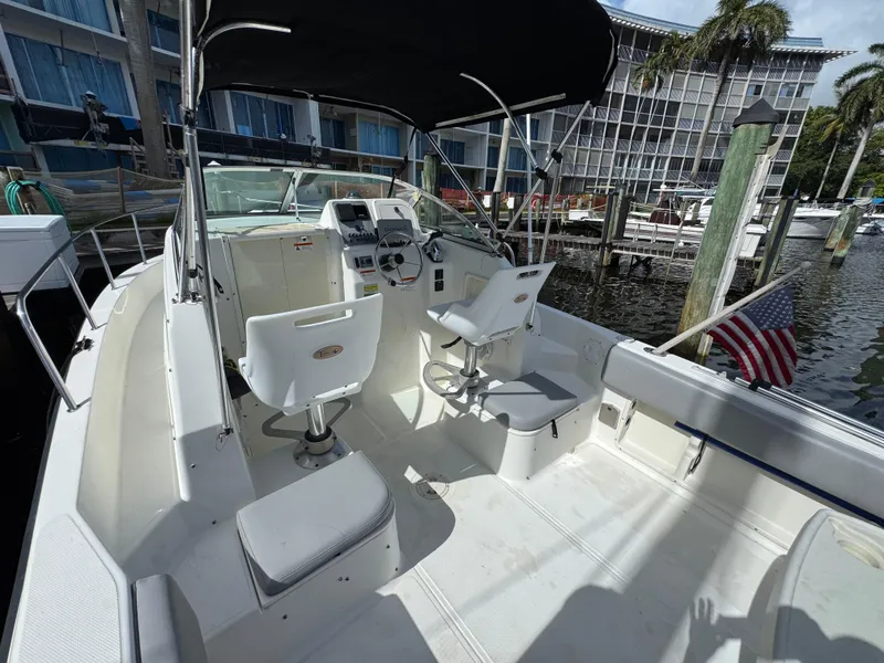 Slide: The Image of 2005 Hydra-Sports Lightning 230 WA boat interior with helm, seats, and American flag at dock. - 7