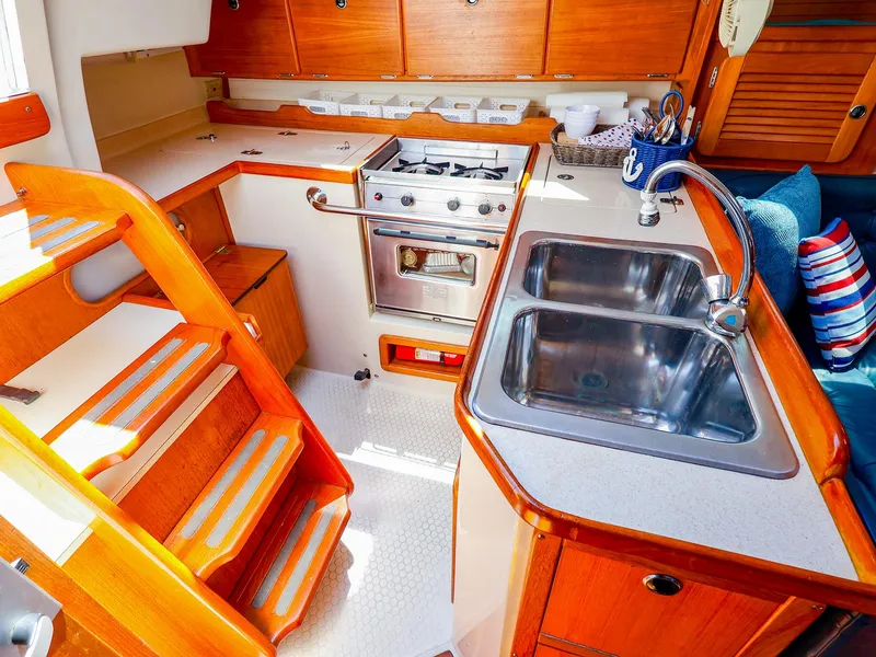 Slide: The Image of Interior of 2001 Catalina 36 MkII sailboat kitchen with wooden cabinetry and dual sinks. - 20